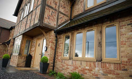 large tudor style home with flush casement residence windows and doors installed with nice brick layout title=